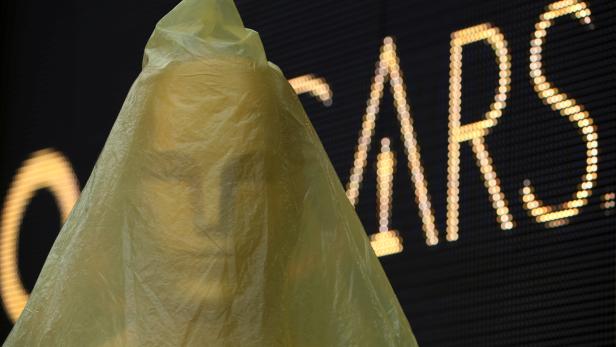 An Oscar statue is protected from the rain with a plastic cover during the preparations for the 90th Academy Awards in Hollywood, Los Angeles