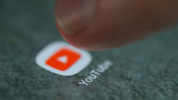 Ein Finger tippt auf das YouTube-App-Symbol auf einem Smartphone.
