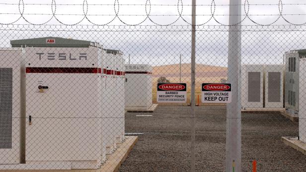 Warning signs adorn the fence surrounding the compound housing the Hornsdale Power Reserve, featuring the world's largest lithium ion battery made by Tesla, during the official launch near the South Australian town of Jamestown