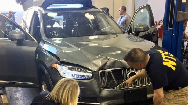 FILE PHOTO: NTSB investigators examine a self-driving Uber vehicle involved in a fatal accident in Tempe