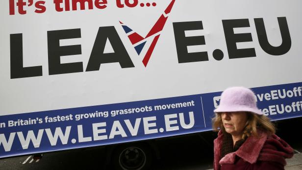 A woman walks past a Leave.EU campaign mobile advertising board in central London
