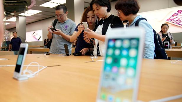FILE PHOTO: Customers look at  Apple's new iPhone 8 Plus after it goes on sale at an Apple Store in Shanghai