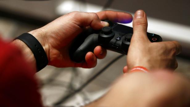 A man uses a Sony PlayStation controller during the Gamescom 2015 fair in Cologne