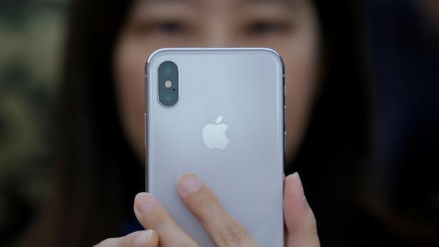 FILE PHOTO: A attendee uses a new iPhone X during a presentation for the media in Beijing