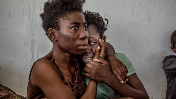 Nigerianische Migranten weinen und umarmen sich im August 2016 in einem Auffanglager.