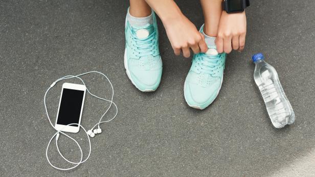 Woman tying shoes laces before running top view