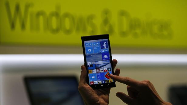 A Microsoft representative shows a smartphone with Windows 10 operating system at the CeBIT trade fair in Hanover in this file photo