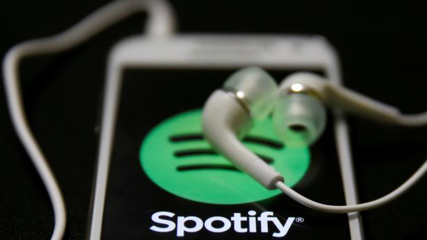 FILE PHOTO: Earphones are seen on top of a smart phone with a Spotify logo on it