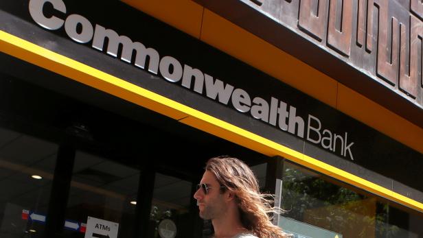 FILE PHOTO: A man walks past a branch of the Commonwealth Bank of Australia in central Sydney
