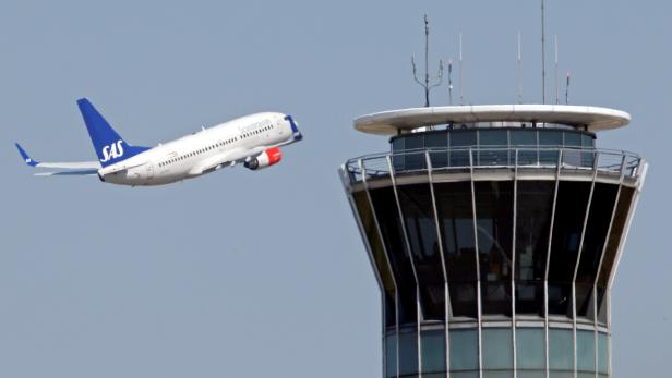 FILE PHOTO -  A Scandinavian SAS airline passenger plane flies near the air traffic control tower at Roissy airport, near Paris