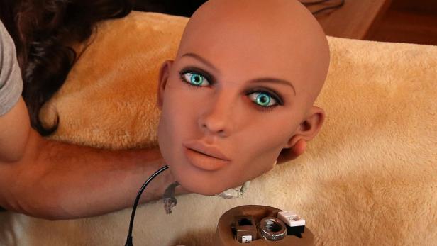 Catalan nanotechnology engineer Sergi Santos holds the head of Samantha, a sex doll packed with artificial intelligence providing her the capability to respond to different scenarios and verbal stimulus, in his house in Rubi, north of Barcelona