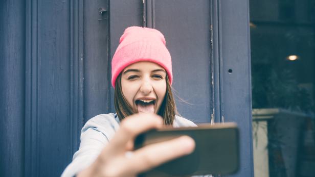 Teenager girl make selfie and making grimaces