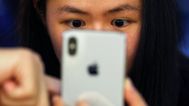 FILE PHOTO: A customer is shown a new iPhone X at an Apple Store in Beijing