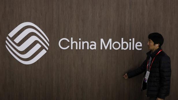 A man walks past the China Mobile logo at the Mobile World Congress in Barcelona