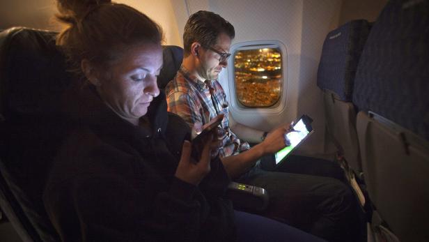 People use their smart devices on an American Airlines airplane, which is equipped with Gogo Inflight Internet service, enroute from Miami to New York