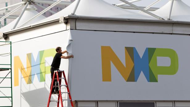 FILE PHOTO: A man works on a tent for NXP Semiconductors in preparation for the 2015 International Consumer Electronics Show (CES) at Las Vegas Convention Center in Las Vegas
