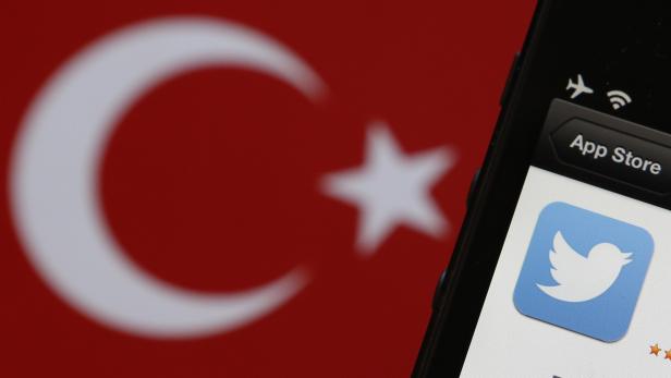 Photo illustration of Twitter logo on an iPhone display next to a Turkish flag