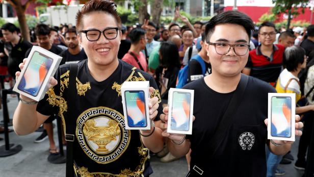 FILE PHOTO: First customers to buy iPhone X Kittiwat Wang, 22, and Mod, 22, of Bangkok pose with their iPhone X at the Apple store in Singapore