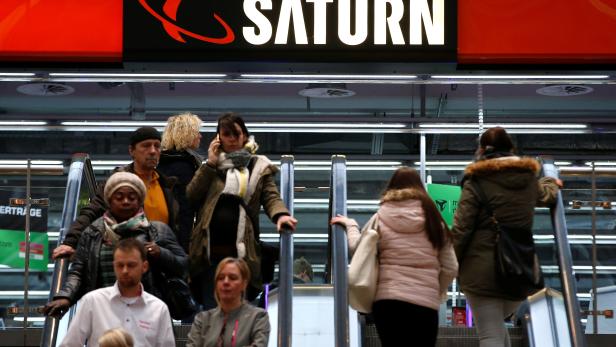 FILE PHOTO: People use escalators at a Saturn electronic retailer inside a shopping mall in Magdeburg