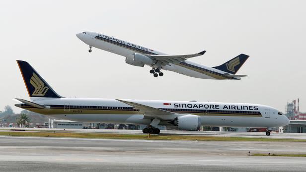 FILE PHOTO: A Singapore Airlines Airbus A330 plane takes off behind a Boeing 787 Dreamliner at Changi Airport in Singapore