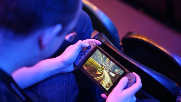 A fan plays Rocket League on a Nintendo Switch during day one of the Rocket League Championship Series Finals in London