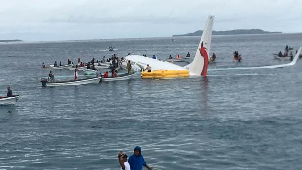 People are evacuated from an Air Niugini plane crashed in the waters in Weno, Chuuk, Micronesia