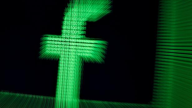 FILE PHOTO: A 3D-printed Facebook logo is seen in front of displayed binary digits in this illustration
