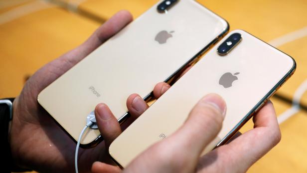 A customer compares the size of the new iPhone XS and iPhone XS Max at the Apple Store in Singapore