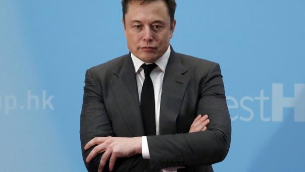 FILE PHOTO: Tesla Chief Executive Elon Musk stands on the podium as he attends a forum on startups in Hong Kong