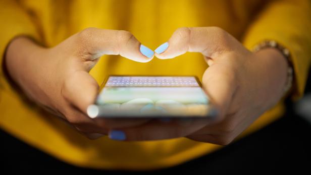 Woman Typing Phone Message On Social Network At Night