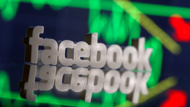 FILE PHOTO: A 3D-printed Facebook logo is seen in front of displayed stock graph