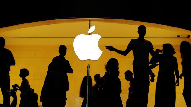Customers walk past an Apple logo inside of an Apple store at Grand Central Station in New York