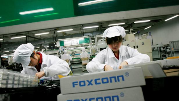 FILE PHOTO: Employees work inside a Foxconn factory in the township of Longhua in the southern Guangdong province