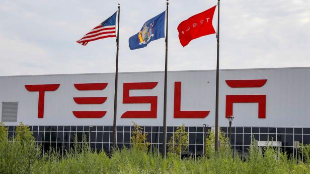 FILE PHOTO: Flags fly over the Tesla Inc. Gigafactory 2, which is also known as RiverBend, a joint venture with Panasonic to produce solar panels and roof tiles in Buffalo, New York