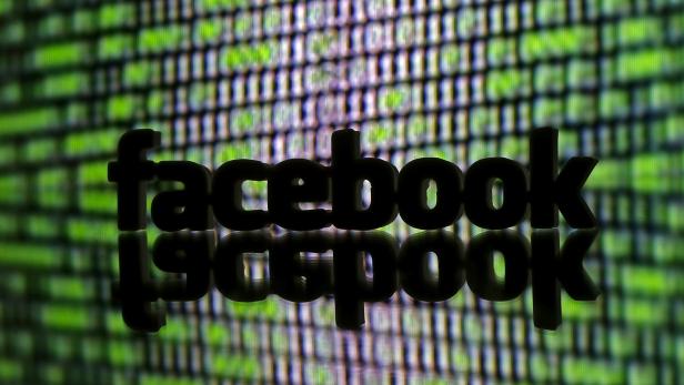 FILE PHOTO: A 3D printed Facebook logo is seen in front of displayed cyber code