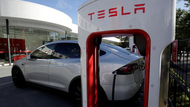 FILE PHOTO: A Tesla Model X vehicle is charged by a supercharger outside a Tesla electric car dealership in Sydney