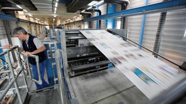 A staff loads a printing plate in the KBA rotary press at the Centre d'Impression Lausanne in Bussigny