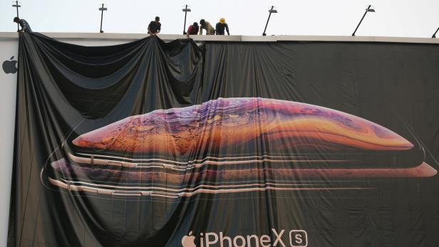 FILE PHOTO: Workers adjust a hoarding of the newly launched iPhone XS in Ahmedabad