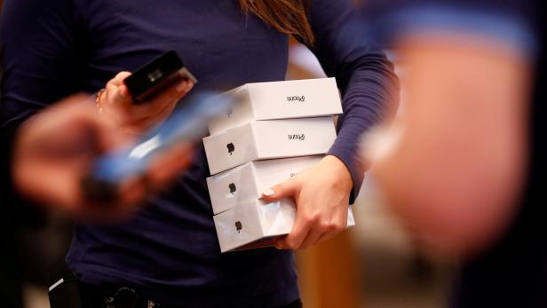 FILE PHOTO: Apple staff hold iPhone X packages at the Apple Store in Berlin