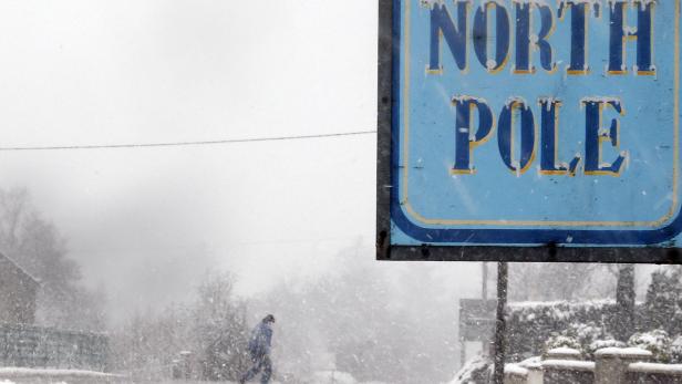 A man walks past The North Pole bar during a blizzard near the village of Carndonagh in Ireland