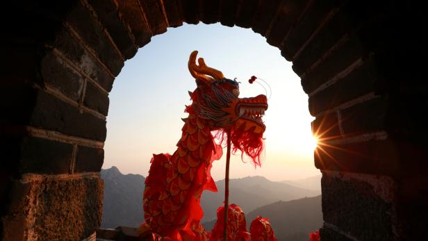 Performers take part in a dragon dance during sunrise at the Mutianyu section of the Great Wall of China in Huairou district of Beijing