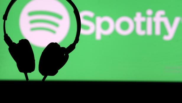 FILE PHOTO: A headset is seen in front of a screen projection of Spotify logo, in this picture illustration