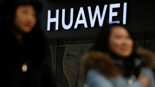 A woman walks past a Huawei shop in Beijing