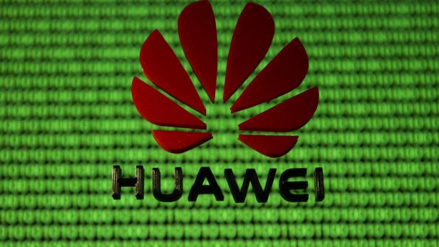 FILE PHOTO: A 3D printed Huawei logo is placed on glass above displayed cyber binary code in this illustration