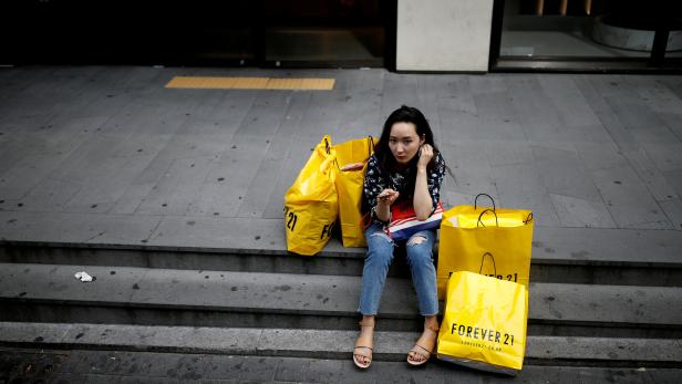 FILE PHOTO: A woman uses her mobile phone at Myeongdong shopping district in Seoul