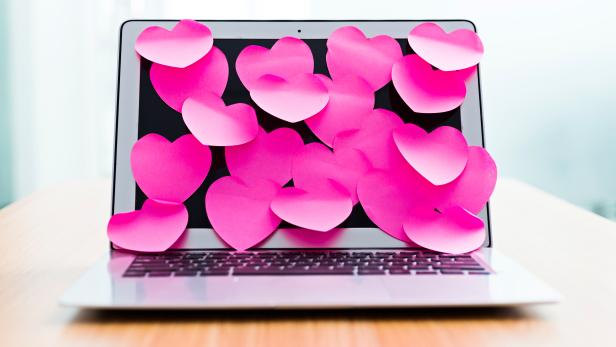 Laptop screen covered by heart shape adhesive notes