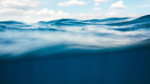 CO2-Entfernung aus Meerwasser soll die Klimakrise ein klein wenig bekämpfen helfen (Symbolbild). Meerwasser, darüber blauer Himmel mit Wolken