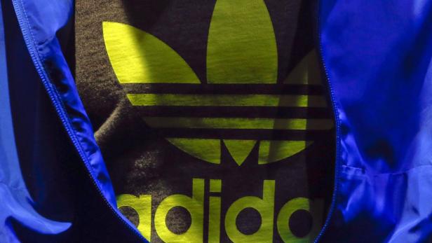 The Adidas logo is pictured on a shirt during the company&#039;s annual news conference in Herzogenaurach March 7, 2013. Adidas, the world&#039;s second largest sports apparel firm, reported an unexpected loss in the fourth quarter due to writedowns linked to the weak performance of its struggling Reebok brand in the United States and Latin America. REUTERS/Michael Dalder (GERMANY - Tags: BUSINESS)