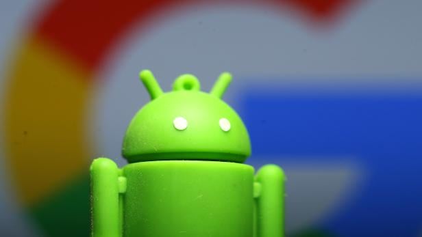 A 3D printed Android mascot Bugdroid is seen in front of a Google logo in this illustration