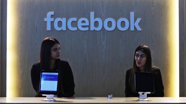 Women wait at Facebook's kiosk at the India Mobile Congress 2018 in New Delhi